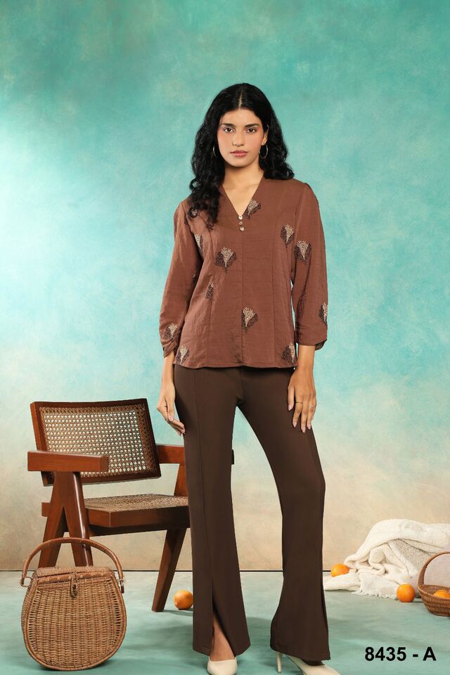 Cocoa textured shirt with split-hem brown trousers against a teal wall