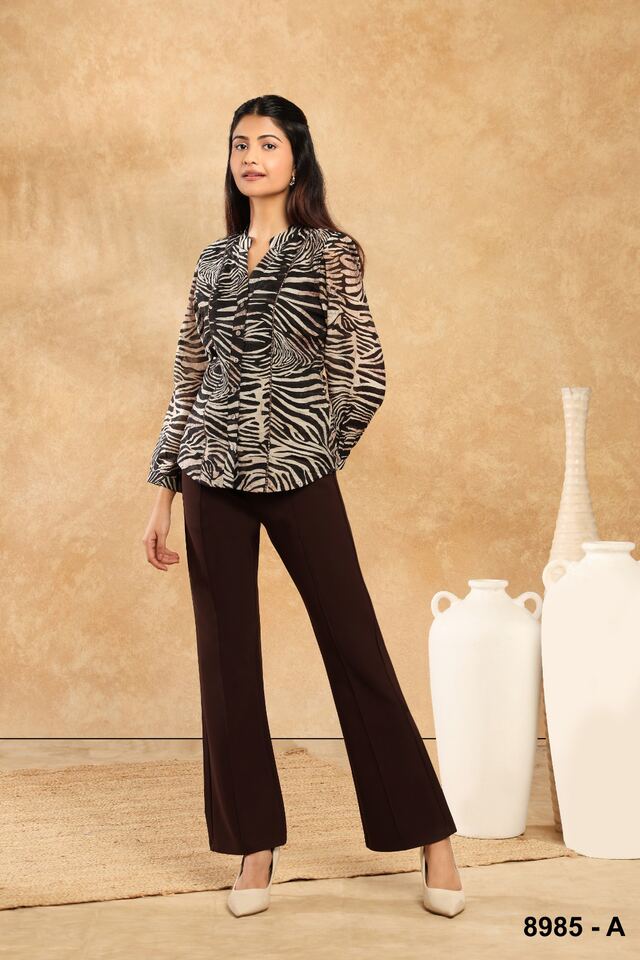 Zebra-print shirt with brown flared trousers in a warm studio setting