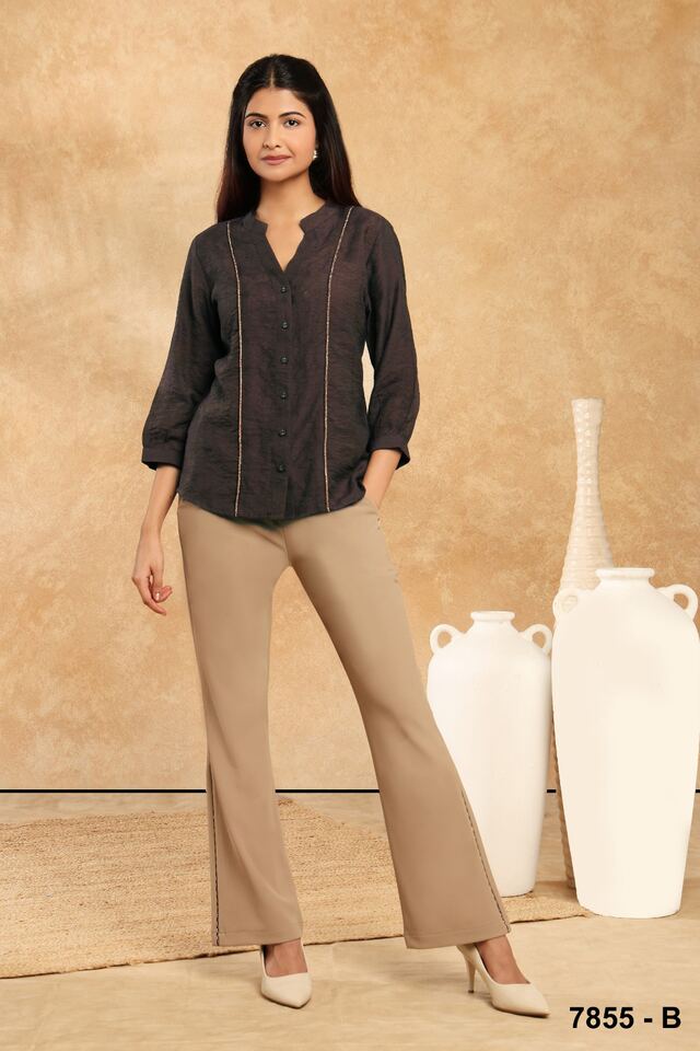 Black textured shirt tucked loosely into wide camel trousers